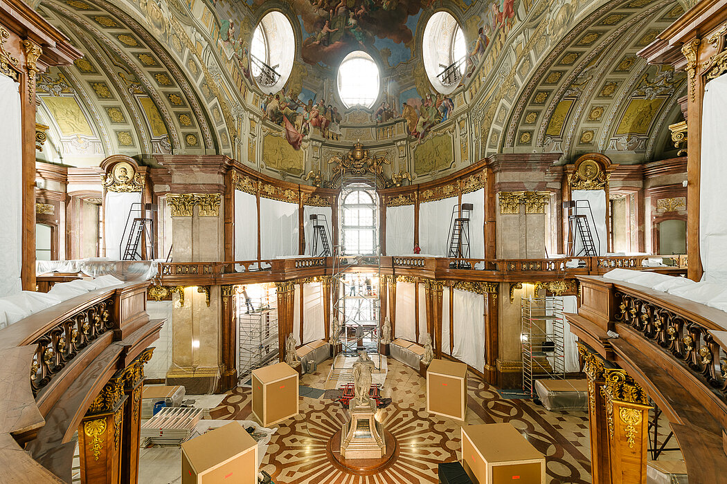 Prunksaal mit verhüllten Statuen und Werkzeug aus der Vogelperspektive.