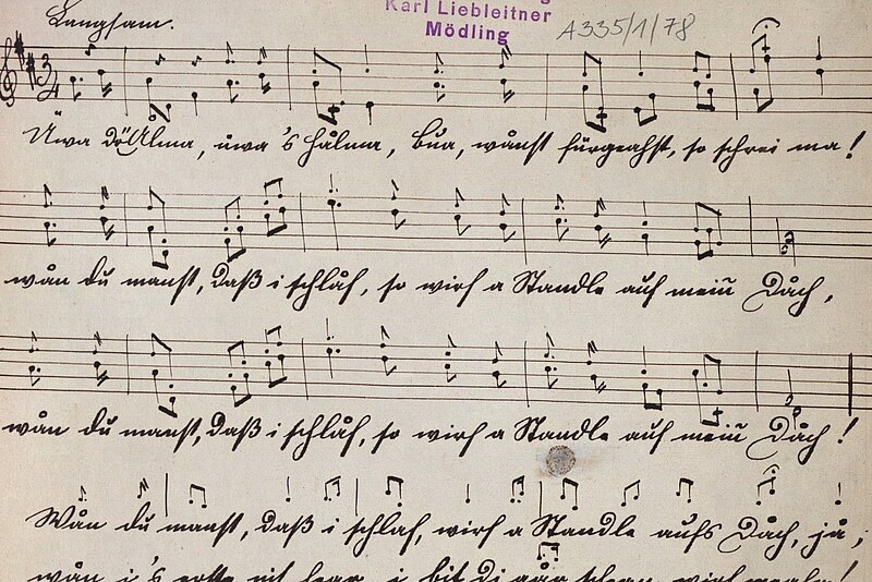 Notenblatt mit handschriftlichem Text.